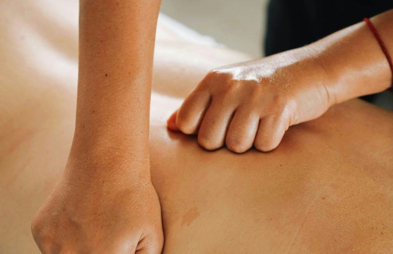 Une personne effectue un massage sur le dos d'une personne allongée.